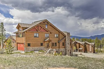 a large wooden house with mountains in the background at Peaceful Fraser Condo with Patio - by Hiking Trails! in Fraser