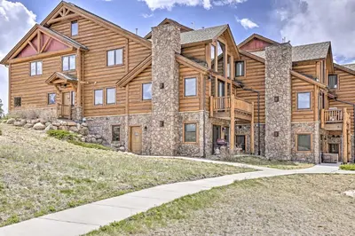 a large log cabin house with a driveway at Peaceful Fraser Condo with Patio - by Hiking Trails! in Fraser