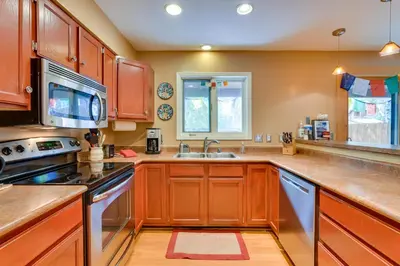 a kitchen with wooden cabinets and a sink at 2 Mi to Frisco Ski Hill Mountain Home with Hot Tub! in Frisco