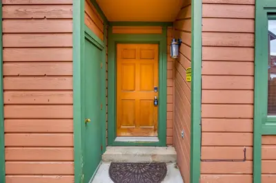 an orange door on the side of a house at 2 Mi to Frisco Ski Hill Mountain Home with Hot Tub! in Frisco