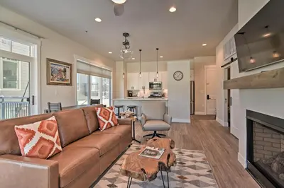 a living room with a couch and a fireplace at Downtown Winter Park Condo - 3 Miles to Ski Resort in Winter Park