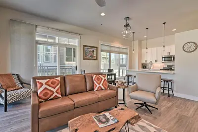 a living room and kitchen with a couch and a table at Downtown Winter Park Condo - 3 Miles to Ski Resort in Winter Park
