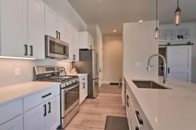 a kitchen with white cabinets and a stove top oven at Downtown Winter Park Condo - 3 Miles to Ski Resort in Winter Park