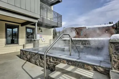 a hot tub on a stone wall outside of a house at Downtown Winter Park Condo - 3 Miles to Ski Resort in Winter Park