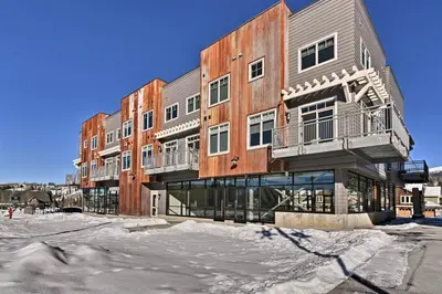 a large building with snow in front of it at Downtown Winter Park Condo - 3 Miles to Ski Resort in Winter Park