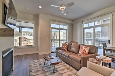 a living room with a couch and a table at Downtown Winter Park Condo - 3 Miles to Ski Resort in Winter Park