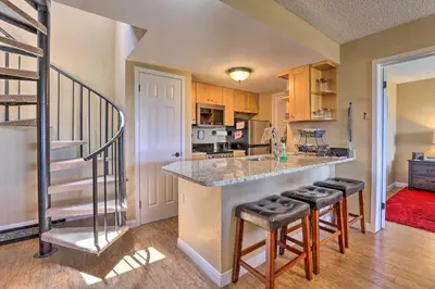 a kitchen with a counter and stools in a room at Walk to Ski Lift Mtn-View Granby Ranch Condo in Granby