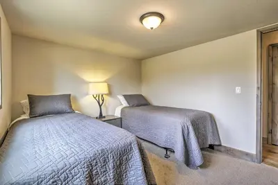 a bedroom with two beds and a lamp in it at Updated Cabin with Hot Tub about 11 Mi to Winter Park! in Tabernash