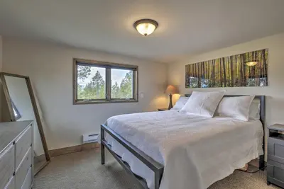 a bedroom with a large bed and a window at Updated Cabin with Hot Tub about 11 Mi to Winter Park! in Tabernash