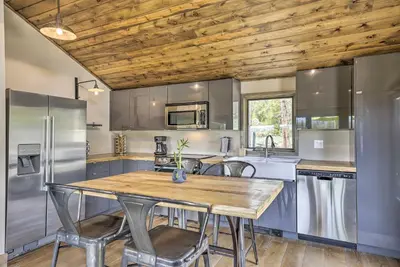 a kitchen with stainless steel appliances and a wooden ceiling at Updated Cabin with Hot Tub about 11 Mi to Winter Park! in Tabernash