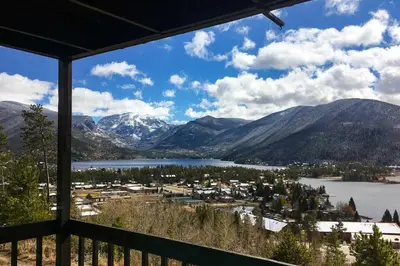 a view of a lake and mountains from a porch at Grand Lake Condo Best Lake View and Panoramic Deck in Grand Lake