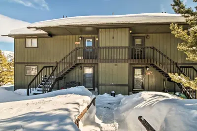 a house with snow on the ground in front of it at Grand Lake Condo Best Lake View and Panoramic Deck in Grand Lake