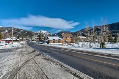 an empty road with snow on the ground and houses at Grand Lake Condo Best Lake View and Panoramic Deck in Grand Lake