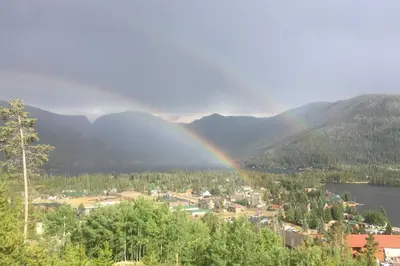 a rainbow over a town and a city with a city at Grand Lake Condo Best Lake View and Panoramic Deck in Grand Lake