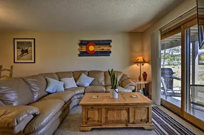 a living room with a leather couch and a coffee table at Eat, Sleep, Ski! Rustic Mtn Condo WiFi,TV, HotTub in Fraser