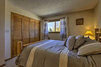 a bedroom with a large bed and a window at Eat, Sleep, Ski! Rustic Mtn Condo WiFi,TV, HotTub in Fraser