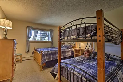 a bedroom with two bunk beds and a window at Eat, Sleep, Ski! Rustic Mtn Condo WiFi,TV, HotTub in Fraser