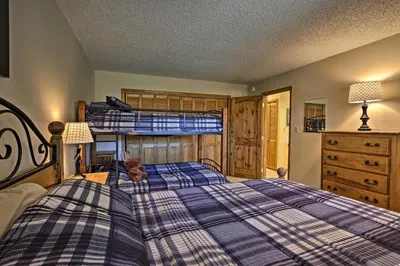 a bedroom with a bed with a bear sitting on it at Eat, Sleep, Ski! Rustic Mtn Condo WiFi,TV, HotTub in Fraser
