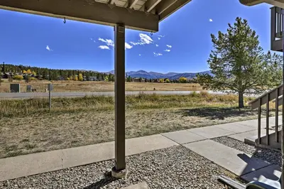 a porch with a view of a field and mountains at Eat, Sleep, Ski! Rustic Mtn Condo WiFi,TV, HotTub in Fraser