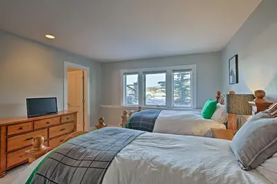 a bedroom with two beds and a television in it at Gorgeous Townhome with Fraser Valley Mountain Views! in Fraser