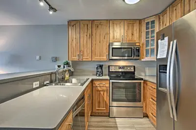 a kitchen with wooden cabinets and stainless steel appliances at Mtn-View Condo with Hot Tub Access in Dillon! in Dillon