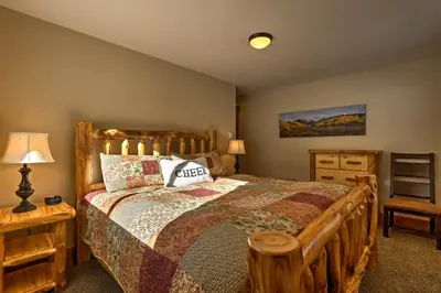a bedroom with a wooden bed and a dresser at Hot Tub! Family Gem on Snake River in Keystone! in Keystone