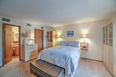 a bedroom with a bed with a blue comforter at Walk to Main St Condo with Deck in Frisco in Frisco