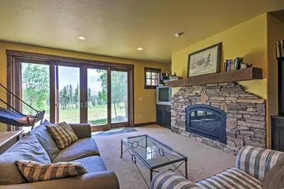 a living room with a couch and a fireplace at Tabernash Retreat with Hot Tub and Stunning Mtn Views! in Tabernash