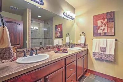 a bathroom with two sinks and a large mirror at Lavish Fraser Townhome with Deck and Mountain Views! in Fraser