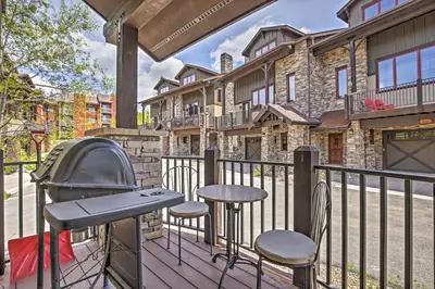 a deck with a grill and two chairs and a table at Lavish Fraser Townhome with Deck and Mountain Views! in Fraser