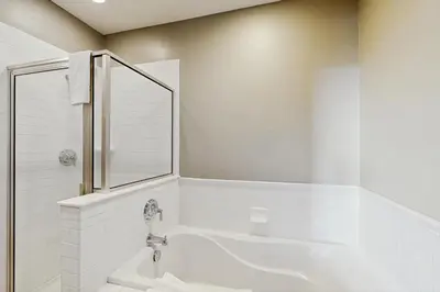 a white bathroom with a tub and a mirror at Base Camp One 112 in Granby