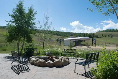 a fire pit in a park with two benches at Base Camp One 112 in Granby