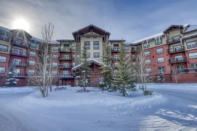 a large apartment building with snow in front of it at Base Camp One 112 in Granby