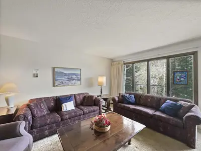 a living room with brown leather couches and a table at CC43 Chateau Claire condo in Dillon