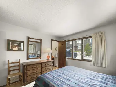 a bedroom with a bed and a chair and a window at CC43 Chateau Claire condo in Dillon
