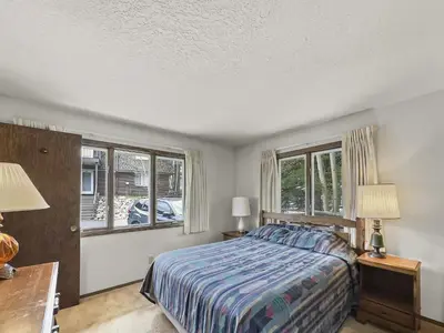 a bedroom with a bed and two windows at CC43 Chateau Claire condo in Dillon