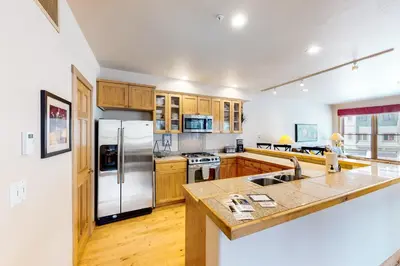 a kitchen with wooden cabinets and a stainless steel refrigerator at Mill Creek #203 in Keystone