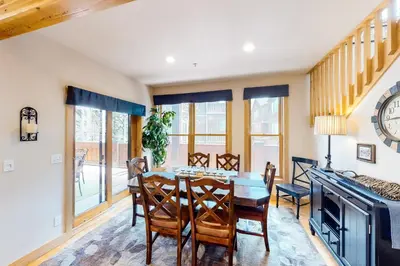 a dining room with a table and chairs and a clock at Mill Creek #203 in Keystone