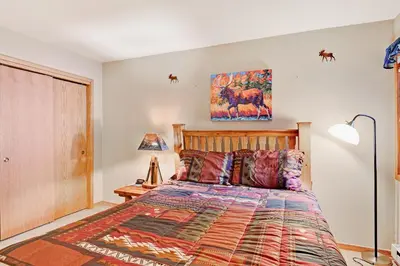 a bedroom with a bed and a painting on the wall at Ski Run Condominiums #108 in Keystone