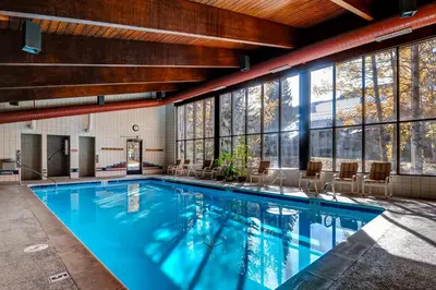 a pool in a building with chairs and windows at Ski Run Condominiums #108 in Keystone