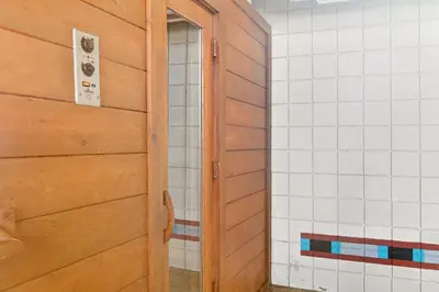 a bathroom with a wooden door and white tiled walls at Ski Run Condominiums #108 in Keystone