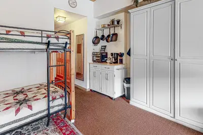 a bedroom with two bunk beds and a kitchen at Gateway #5055 in Keystone