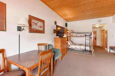 a dining room and living room with a table and a bunk bed at Gateway #5055 in Keystone