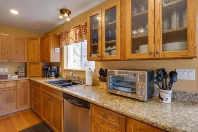a kitchen with wooden cabinets and a microwave at Empire Vacation Rental with Fire Pit and Gas Grill! in Empire