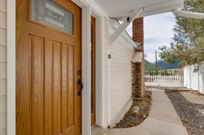 a house with a wooden door and a sidewalk at Empire Vacation Rental with Fire Pit and Gas Grill! in Empire