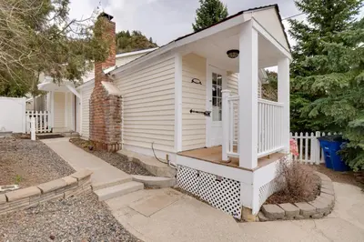 a small white house with a porch at Empire Vacation Rental with Fire Pit and Gas Grill! in Empire