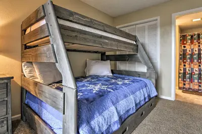a bedroom with a bunk bed with a blue comforter at 1 Mi to Granby Ranch Cozy Condo with Fireplace in Granby