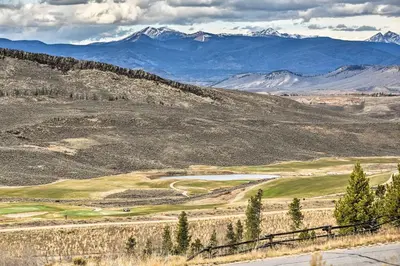 a golf course on a hill with mountains in the background at 1 Mi to Granby Ranch Cozy Condo with Fireplace in Granby