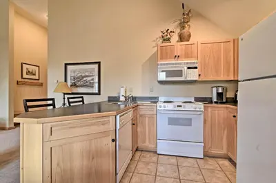 a kitchen with white appliances and wooden cabinets at Keystone Ski Condo with Mtn View - Walk to Gondola! in Keystone