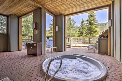 a hot tub in the middle of a room with windows at Keystone Ski Condo with Mtn View - Walk to Gondola! in Keystone